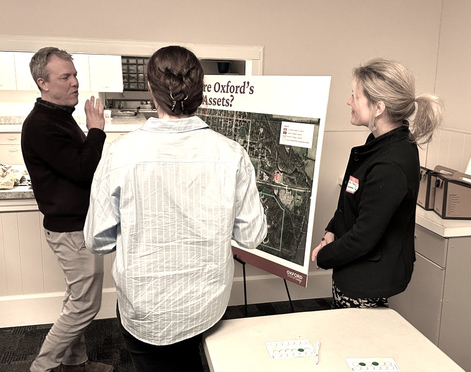 People talking next to a poster board